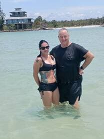 A couple enjoys a refreshing swim in shallow waters, capturing a perfect moment of relaxation and fun at the beach.