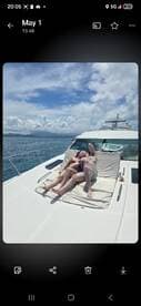A couple enjoys a romantic moment sunbathing on the deck of a yacht, surrounded by stunning ocean views — perfect for a getaway or honeymoon.