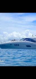 A luxurious yacht glides through serene waters, with guests enjoying the sun — an ideal setting for a relaxing day on the water.