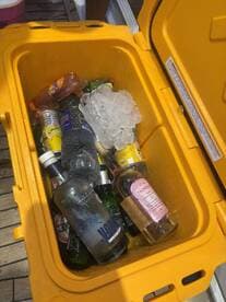 A vibrant cooler filled with a variety of drinks and ice, perfect for keeping refreshments cool during a day on the water.