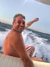A joyful man enjoys a thrilling ride on a boat, capturing the essence of fun and adventure on the open water.