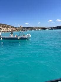A sleek speedboat anchored in crystal-clear turquoise waters, showcasing the beauty of the coastal landscape.