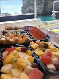 A vibrant display of fresh fruit platters ready for guests aboard a boat, perfect for a refreshing snack during a day on the water.