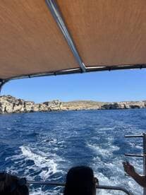 A scenic view from a boat cruising along a beautiful coastline, showcasing the vibrant blue ocean and rocky cliffs — perfect for adventure seekers and nature lovers.