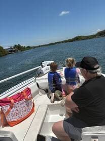 A family enjoys a day on the water, with children in life jackets eagerly taking in the scenery while boating — a perfect adventure for creating lasting memories.