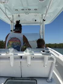 A view from the helm of a boat, showcasing a man and a child preparing for an adventure on the water. The interior features a clean console and ample seating, perfect for family outings.