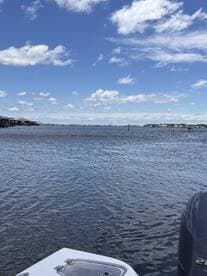 A serene view of the water with a glimpse of a dock in the background, perfect for showcasing boating adventures or waterfront activities.