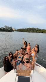 A lively group of friends enjoys a fun day on the boat, celebrating together with drinks and smiles, perfect for a memorable outing on the water.