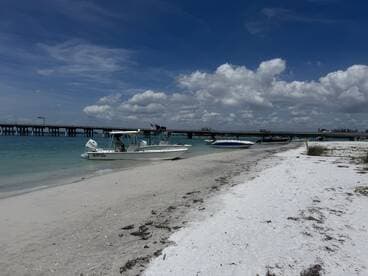 A scenic view of speedboats docked on a sandy beach with a picturesque sky, perfect for a day of relaxation and water activities.