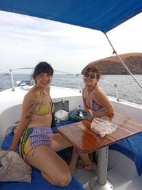 Two friends enjoy a sunny day on a boat, showcasing a fun and relaxed atmosphere perfect for summer outings or celebrations on the water.