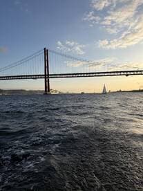 A stunning view of a sailboat navigating the waters beneath a majestic bridge, capturing the essence of a scenic sailing experience.