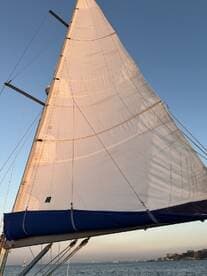 A close-up view of a sailboat's sail against a clear sky, showcasing the beauty of sailing on open waters.