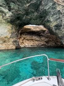 A stunning view of a natural cave framed by crystal-clear turquoise waters, showcasing the beauty of the marine landscape — perfect for exploring hidden gems on a boat trip.