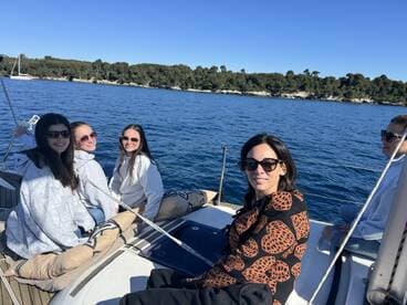 A group of friends enjoys a sunny day sailing on a yacht, capturing the essence of friendship and adventure on the water.