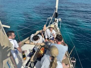 A lively group enjoys a relaxing day on a yacht, sipping cocktails and soaking up the sun — perfect for celebrations and memorable outings on the water.