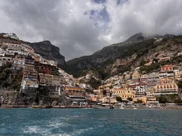 A stunning view of the colorful cliffside village of Positano on the Amalfi Coast, showcasing its picturesque architecture against a dramatic mountainous backdrop.