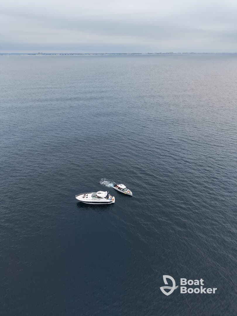 Aerial view of a yacht and a smaller boat navigating through calm waters, showcasing the beauty of boating adventures.