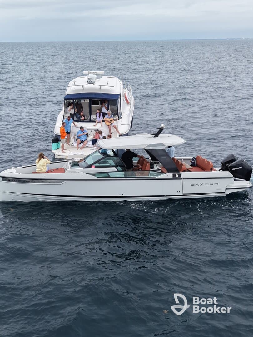 A lively group enjoys a fun day on the water, with music and camaraderie aboard two boats, showcasing the perfect atmosphere for a memorable outing.