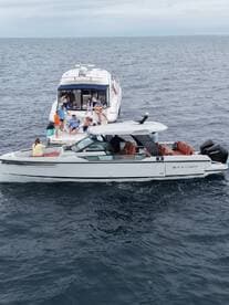 A lively group enjoys a fun day on the water, with music and camaraderie aboard two boats, showcasing the perfect atmosphere for a memorable outing.