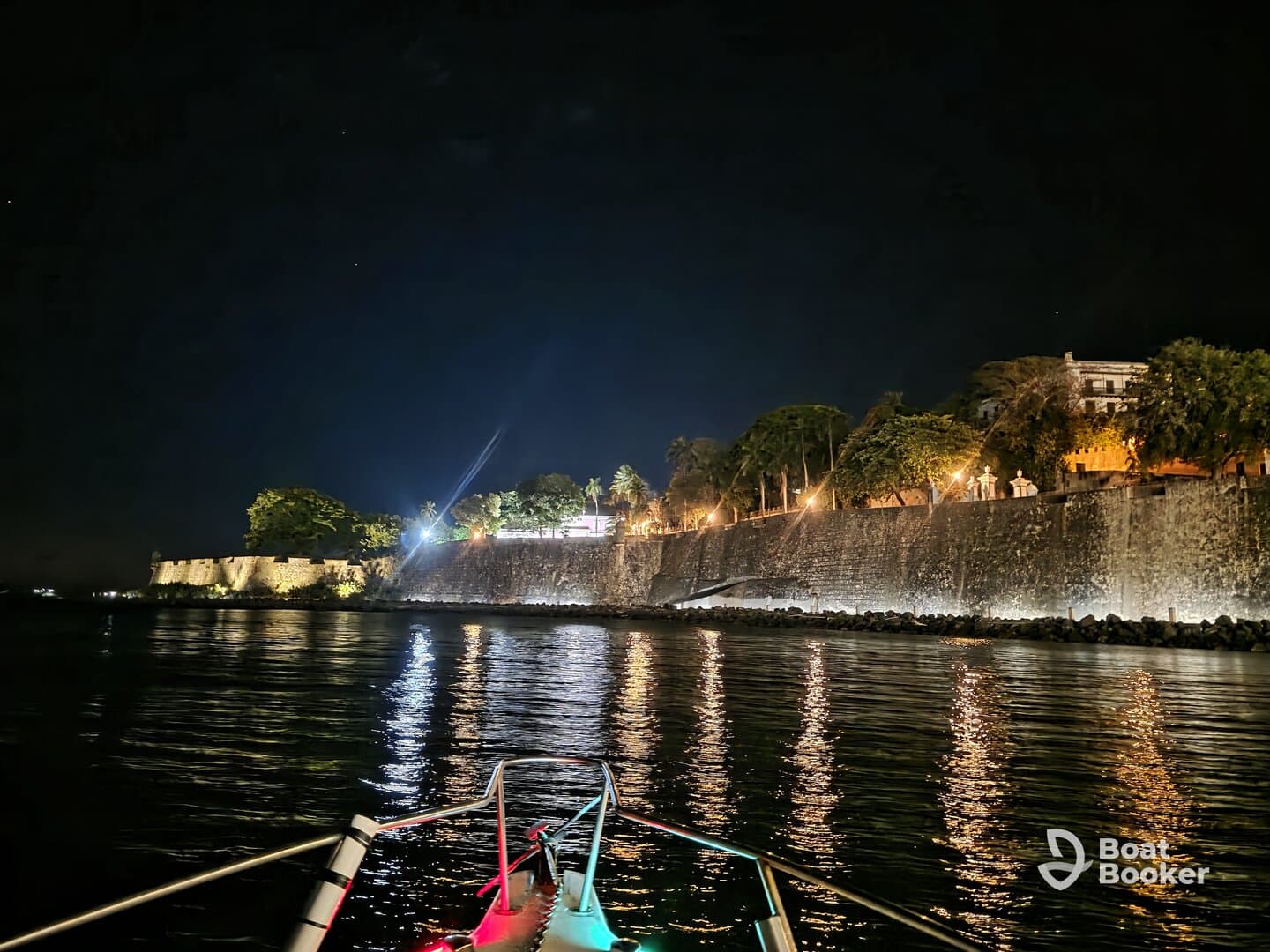 A serene night view from a boat, showcasing illuminated waterfront buildings and reflections on the water — perfect for evening cruises and sightseeing.