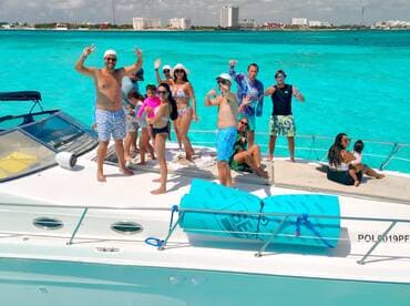 A lively group of friends and family celebrate aboard a boat in stunning turquoise waters, capturing the essence of a perfect day on the water.