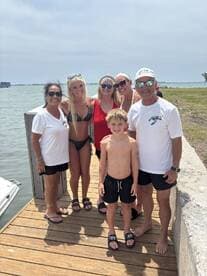 A joyful family poses together on a dock, ready for a fun day by the water — perfect for creating lasting memories during summer adventures.