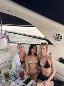 Three friends enjoy a stylish boat party, sipping cocktails and soaking up the sun — perfect for summer celebrations on the water.