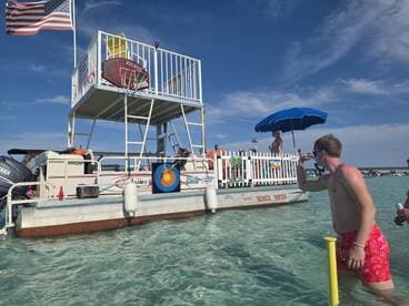 A lively scene on a pontoon boat with guests enjoying the water and activities, perfect for a fun day out in the sun.
