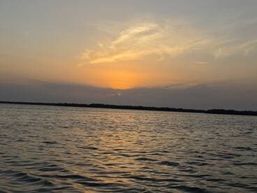 A serene sunset over calm waters, capturing the beauty of nature — perfect for peaceful evening boat rides.