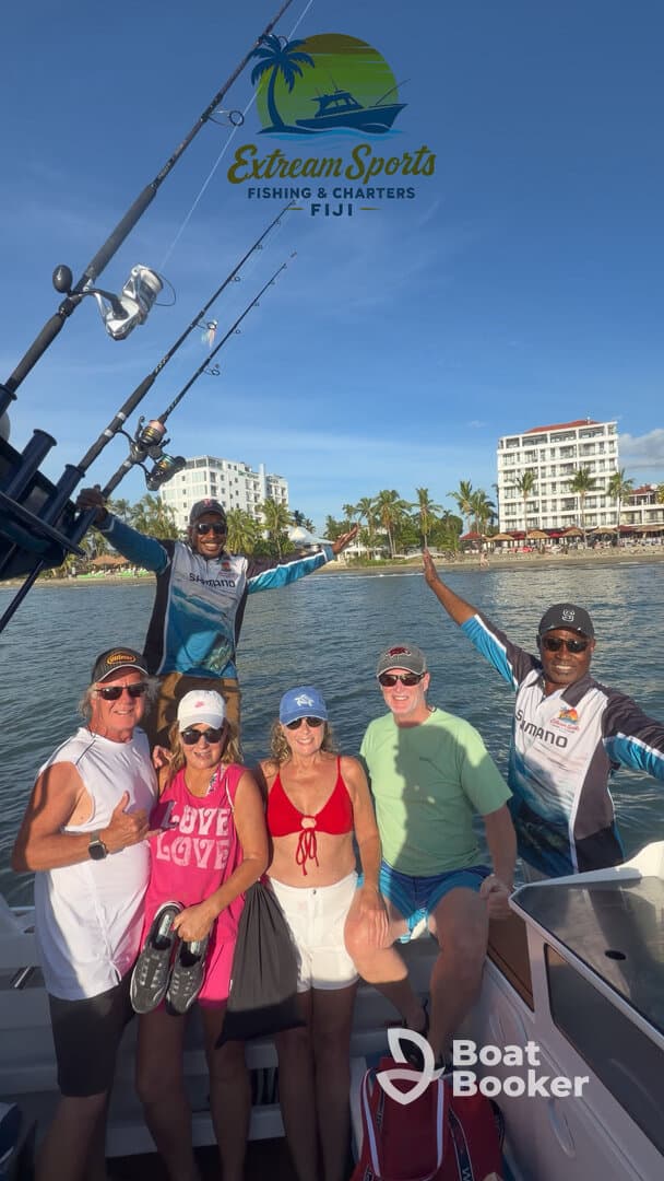 A lively group poses on a fishing charter in Fiji, showcasing their excitement for a day of fishing and adventure on the water.
