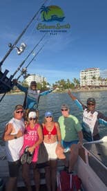 A lively group poses on a fishing charter in Fiji, showcasing their excitement for a day of fishing and adventure on the water.