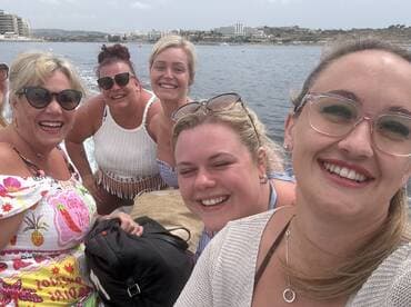 A joyful group of friends smiles for a selfie aboard a boat, capturing the essence of fun and camaraderie on the water.