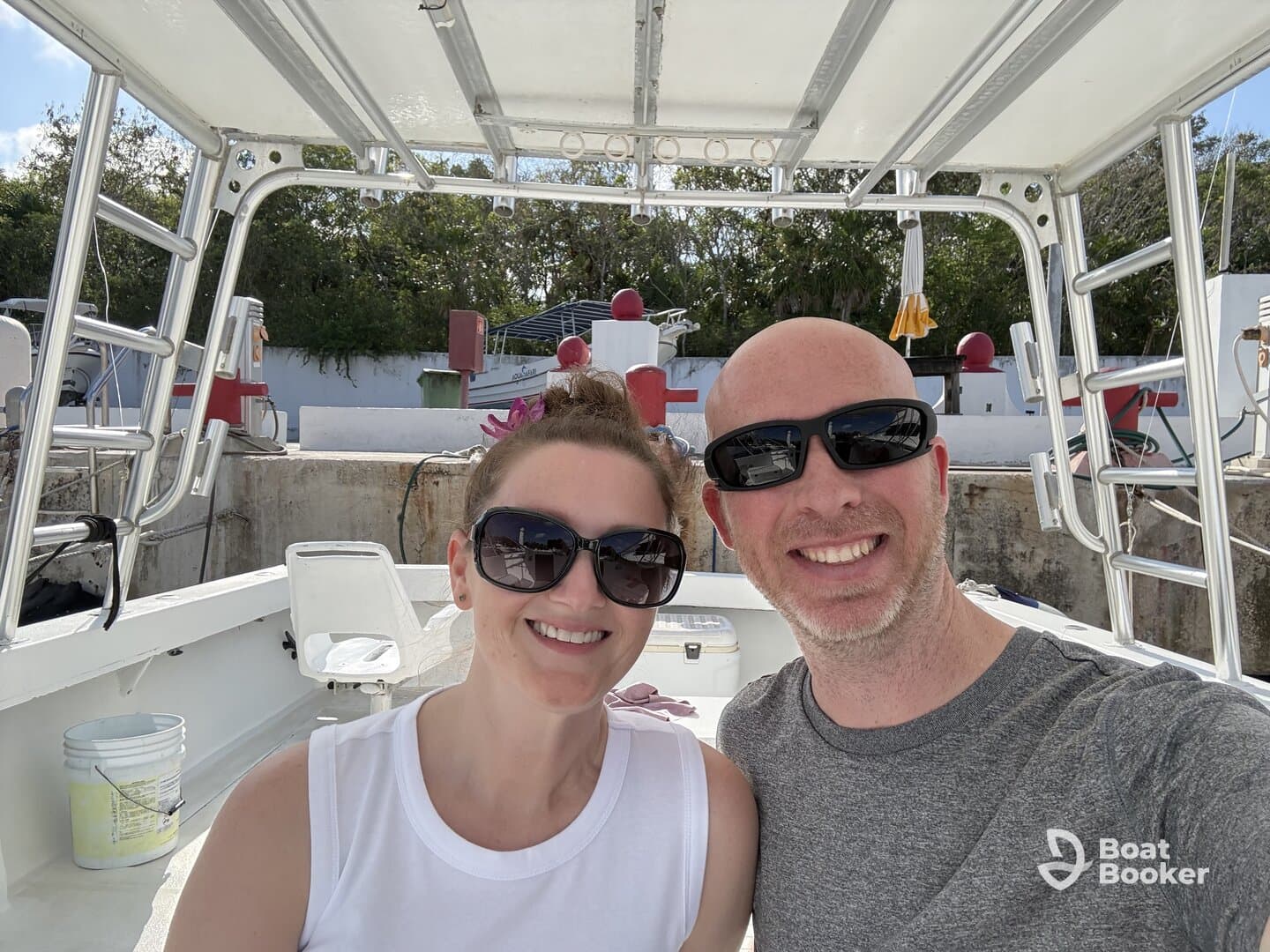 A cheerful couple poses for a selfie aboard a boat, capturing a moment of joy and adventure on the water.