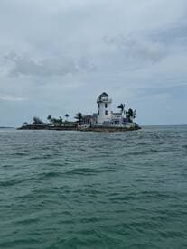A picturesque view of a lighthouse on a small island, surrounded by tranquil waters — a perfect destination for scenic boat tours.