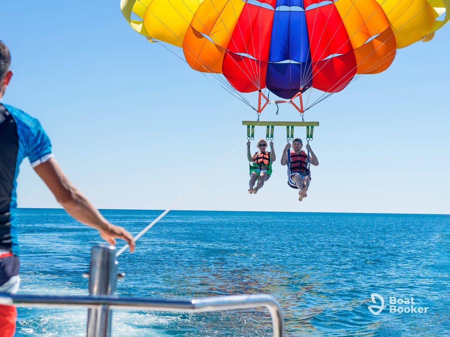 A thrilling parasailing adventure with a couple soaring above the sparkling ocean, showcasing the excitement of water sports.
