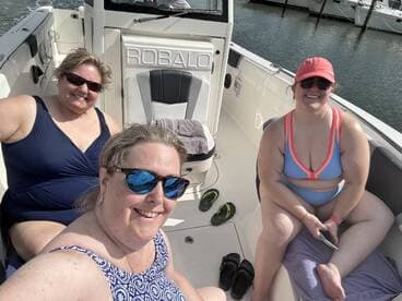 Three friends enjoy a sunny day on a Robalo boat, capturing a fun moment together while relaxing on the water.