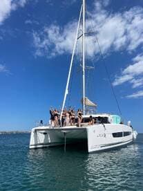 A lively group of friends celebrates aboard a catamaran, enjoying the sun and sea — perfect for unforgettable party experiences on the water.