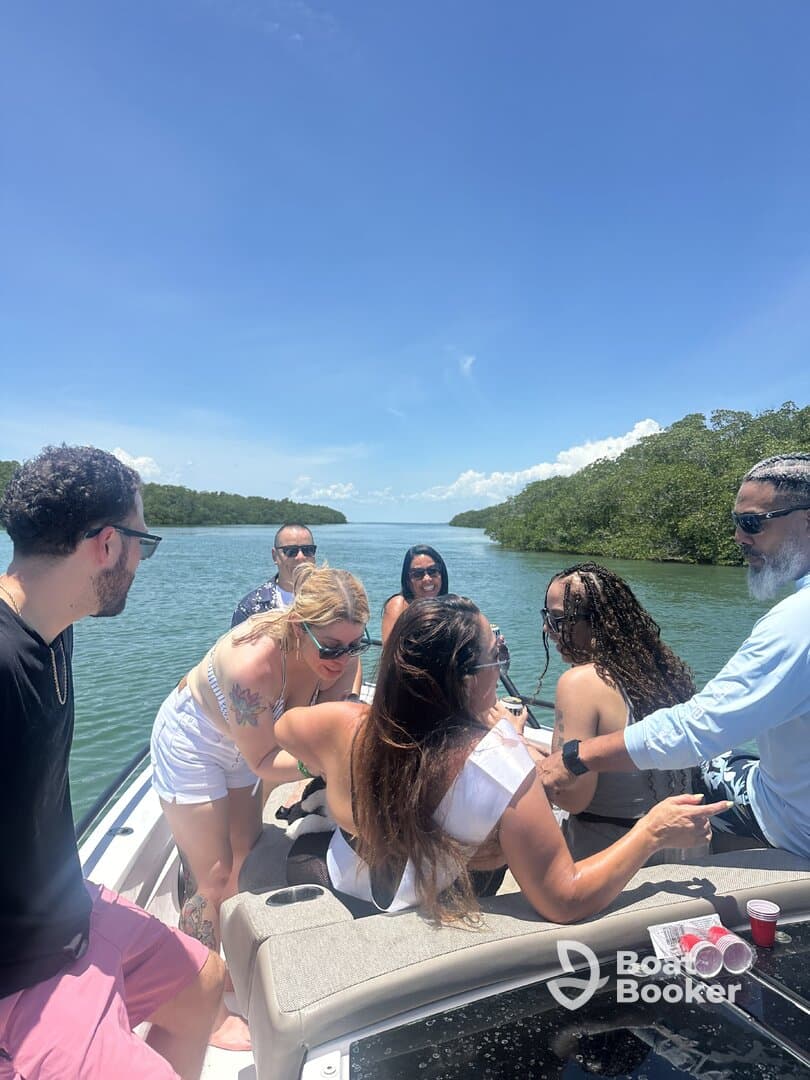 A lively group of friends enjoys a fun day on the water, celebrating together on a boat surrounded by beautiful scenery.