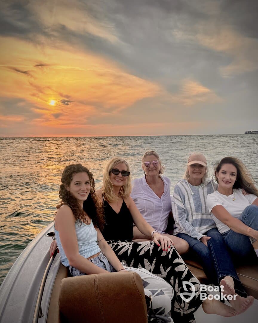 A group of friends enjoys a beautiful sunset on a boat, capturing the perfect moment for a memorable outing on the water.