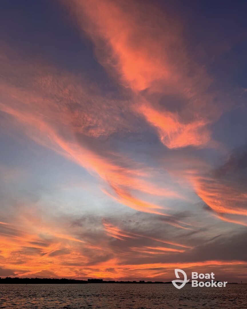A stunning sunset paints the sky with vibrant hues over tranquil waters, creating a picturesque backdrop for evening boat trips.