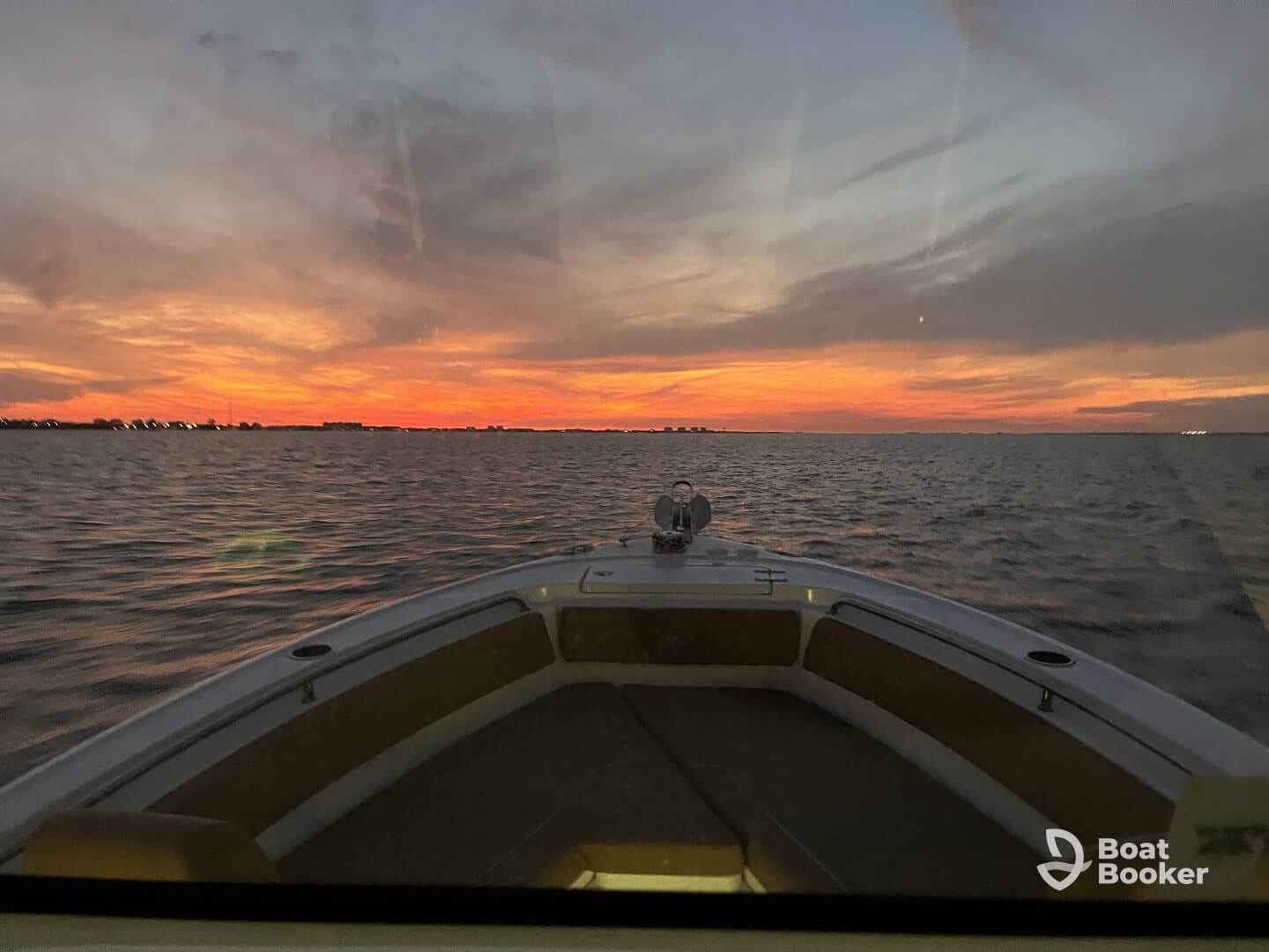 A stunning sunset view from the bow of a boat, showcasing vibrant colors over the water — perfect for evening cruises.