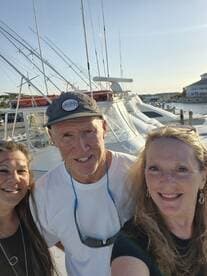 A cheerful group poses for a selfie at the marina, surrounded by boats — capturing the excitement of a day on the water.