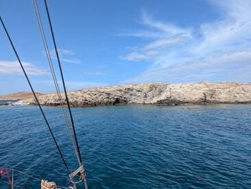 A stunning view of rocky coastline and clear blue waters, perfect for showcasing the natural beauty of the destination while sailing.