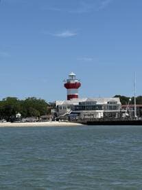 A scenic view of a lighthouse and waterfront building, capturing the essence of coastal charm. Ideal for showcasing local landmarks and maritime culture.