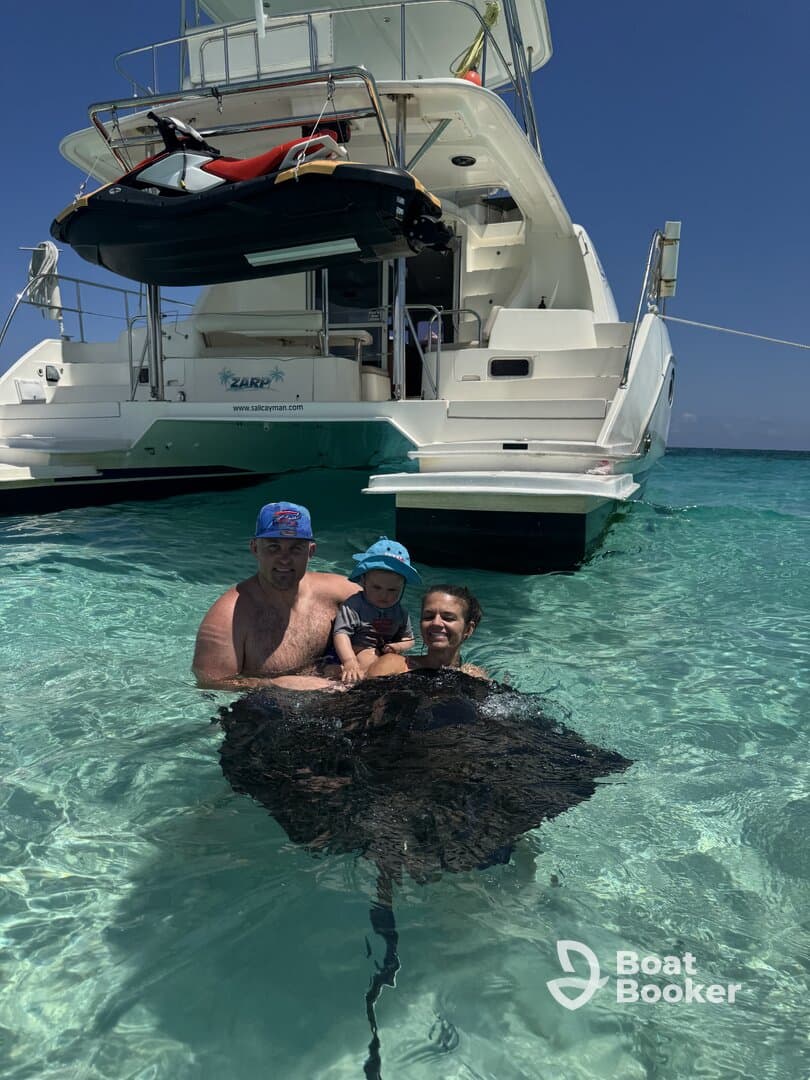 A family enjoys a close encounter with a stingray while swimming in crystal-clear waters, creating unforgettable memories in a tropical paradise.
