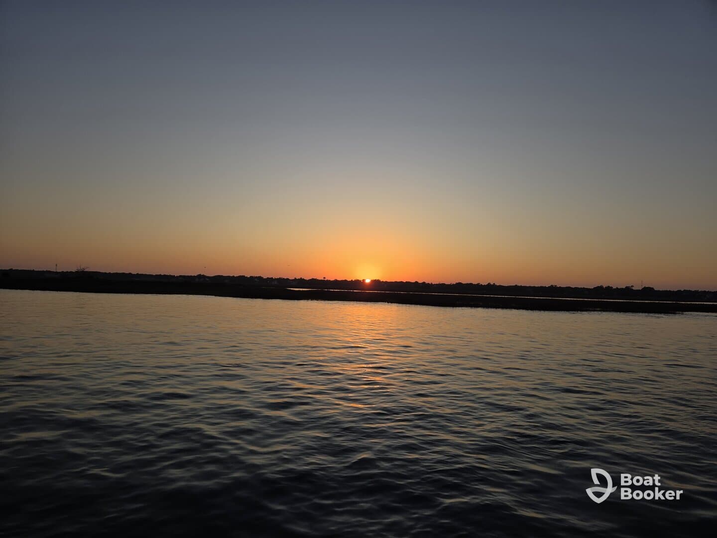 A serene sunset over calm waters, providing a picturesque backdrop for evening boat trips or romantic cruises.