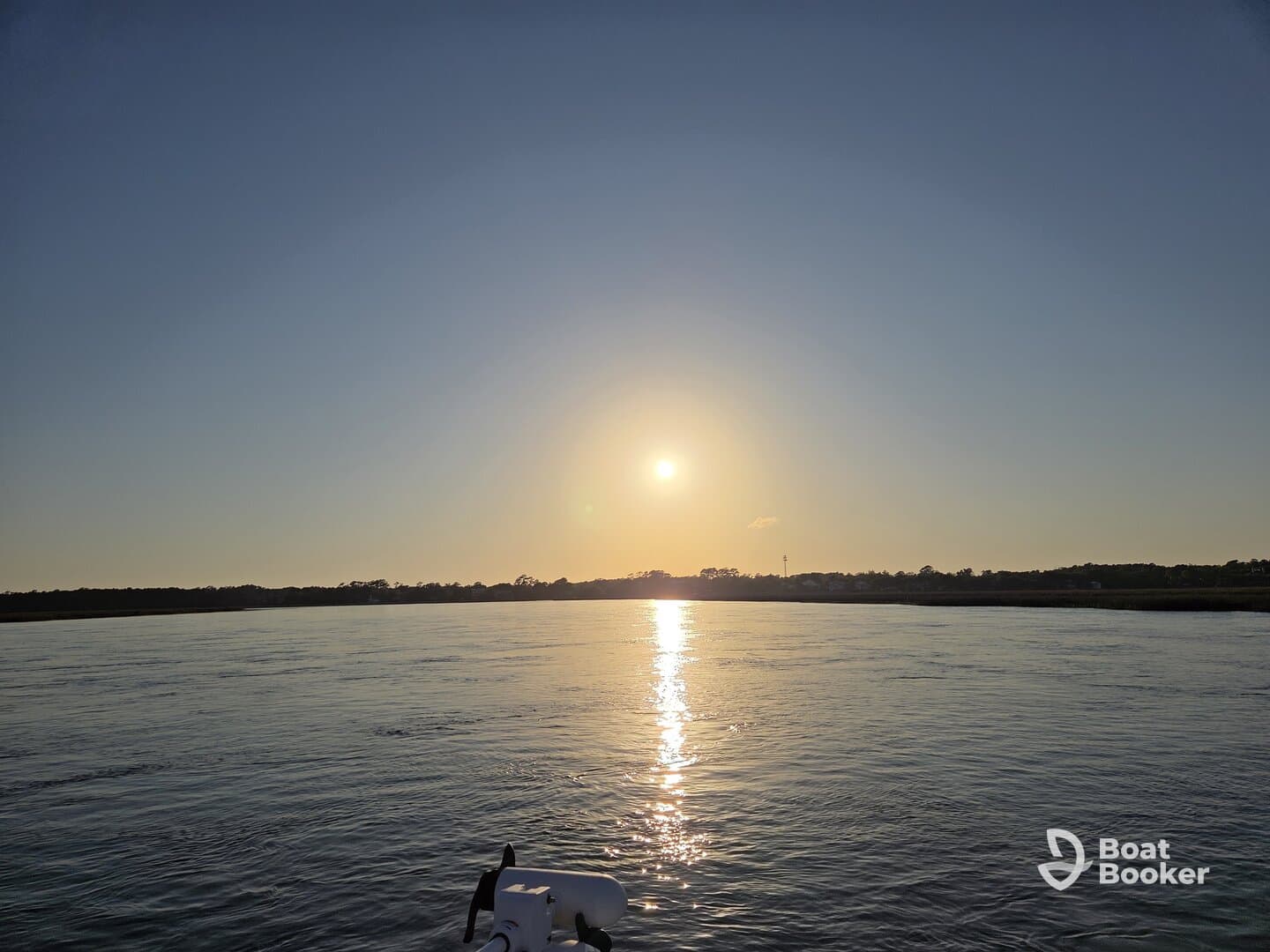 A serene sunset view over calm waters, captured from the bow of a boat, showcasing the tranquil beauty of evening cruises.