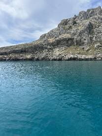 A serene view of turquoise waters against a rugged coastline, perfect for showcasing the natural beauty of the area.