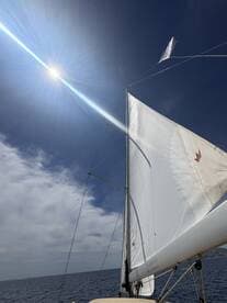 A stunning view of a sailboat's sails catching the sunlight, showcasing the beauty of sailing on open waters.