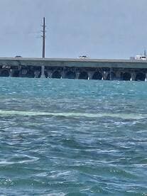 An unclear view of a structure over water, possibly a bridge or pier, with no identifiable subjects or activities.